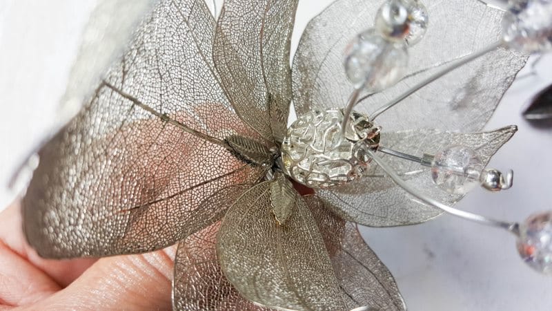Filigree skeleton leaves surrounding the stamen and pistils
