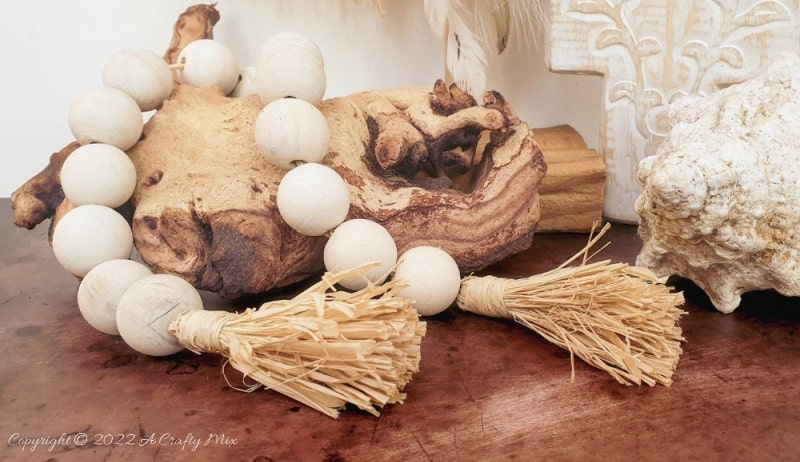 Handmade Raffia Collar Necklace Home D&eacute;cor or Wall Hanging using cardboard and beads. Quick, easy, budget-friendly, and fun to put together, it will add a touch of tribal boho to any space. Get the free step-by-step tutorial at A Crafty Mix. #BohoDecorDIY #ACraftyMix