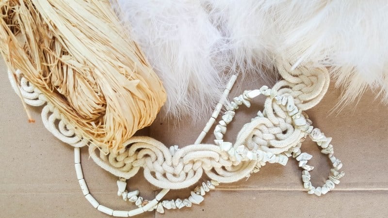 To make the raffia collar necklace you need decorative bits, cardboard and raffia