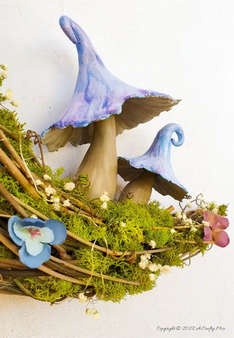 This how-to guide will show you how to make a gorgeous crescent moon wreath from scratch. It includes a step-by-step video tutorial to make fantasy-inspired curly top mushrooms. #ACraftyMix #FantasyWreath