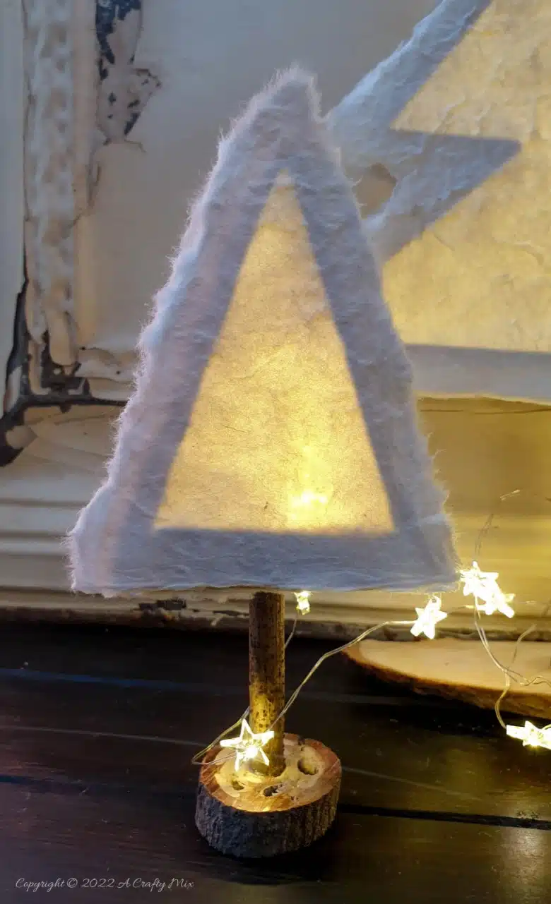 Do you want to make something that's both gorgeous and budget-friendly this festive season? If so, these easy-to-make, handmade paper Christmas trees tick all the right boxes. They look great on the mantle or a table and the lights give them a beautiful warm glow. #ACraftyMix #Tutorial