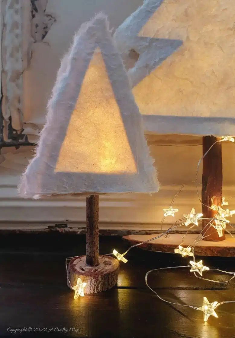 Do you want to make something that's both gorgeous and budget-friendly this festive season? If so, these easy-to-make, handmade paper Christmas trees tick all the right boxes. They look great on the mantle or a table and the lights give them a beautiful warm glow. #ACraftyMix #Tutorial