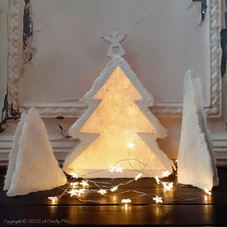 Do you want to make something that's both gorgeous and budget-friendly this festive season? If so, these easy-to-make, handmade paper Christmas trees tick all the right boxes. They look great on the mantle or a table and the lights give them a beautiful warm glow. #ACraftyMix #Tutorial