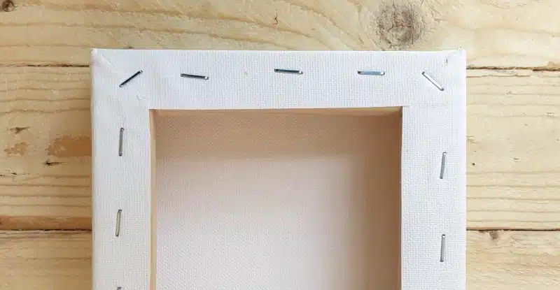 A view of the back side of the canvas with staples