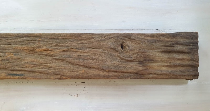 A worn piece of wood with straight cut edges