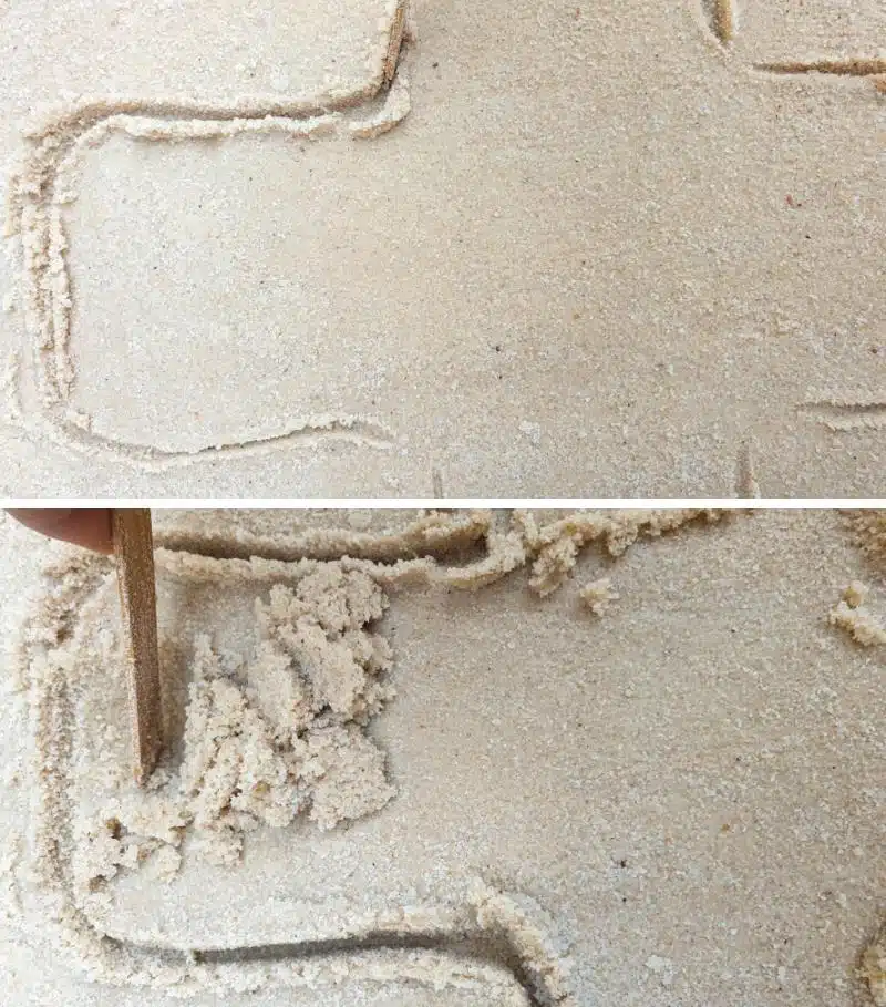 Use your hands and and ice cream stick to carve a cross shape into the wet sand.