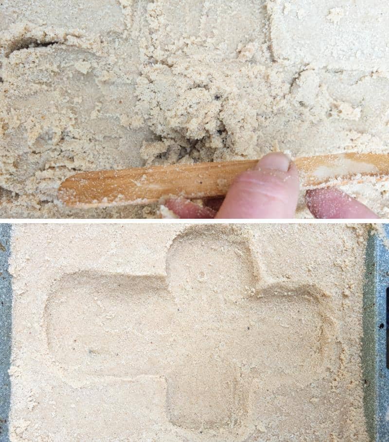 Use your hands and and ice cream stick to carve a cross shape into the wet sand.