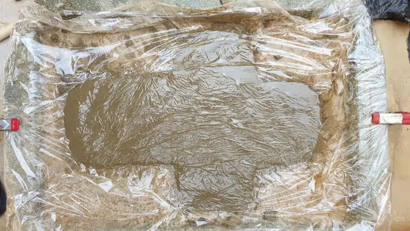 Cover the concrete cross with cling film (Saran Wrap) and leave to cure