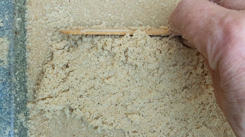 Use and ice cream stick to level the sand