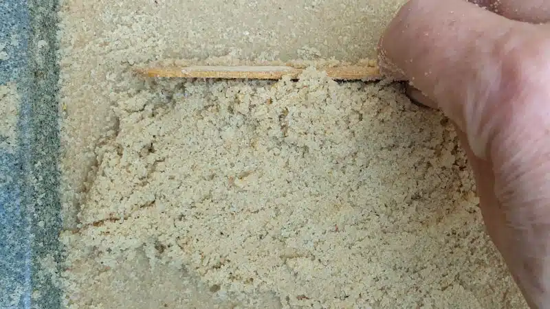 Use and ice cream stick to level the sand