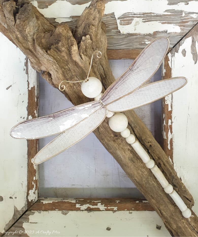 This easy tutorial will who you how to create a large wooden bead dragonfly that is sure to be a conversation starter in any room. You can experiment with different colors, shapes, and sizes to create a one-of-a-kind dragonfly that reflects your personal style and creativity. #ACraftyMix