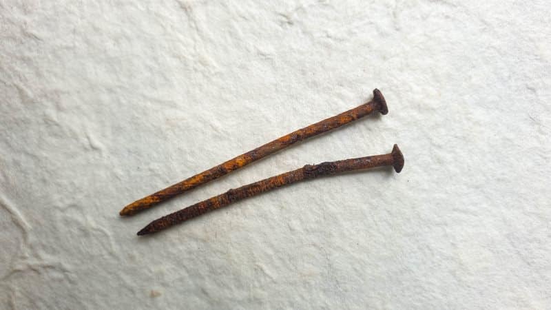 To make a miniature thatch roof paper house you'll need rusty nails, scrap paper and twine