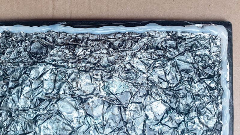 Use hot glue to create a temporary border around the cardboard tray