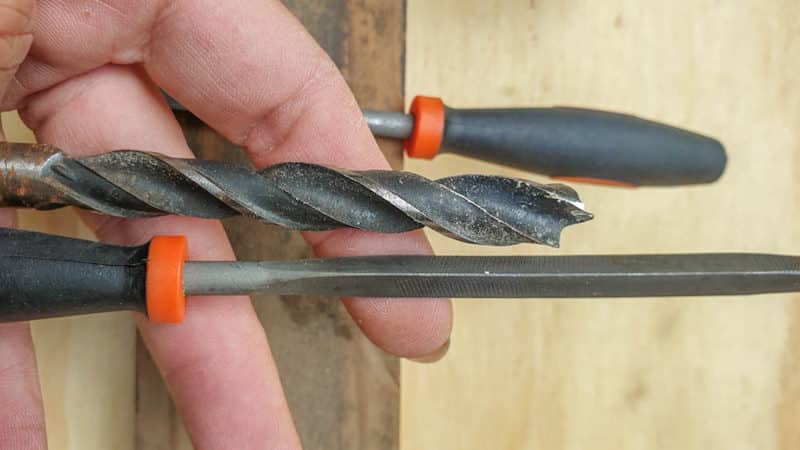 Using the files or screwdrivers as a guide, pick the right drill bit size