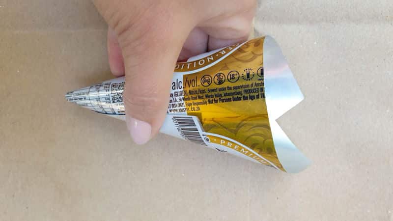 Starting on one long end roll the soda can into a cone shape