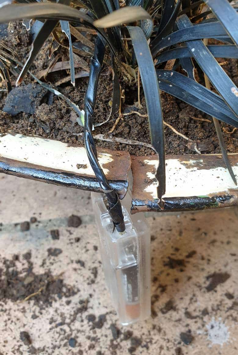 Let the battery pack dangle outside the planter to protect it from water damage