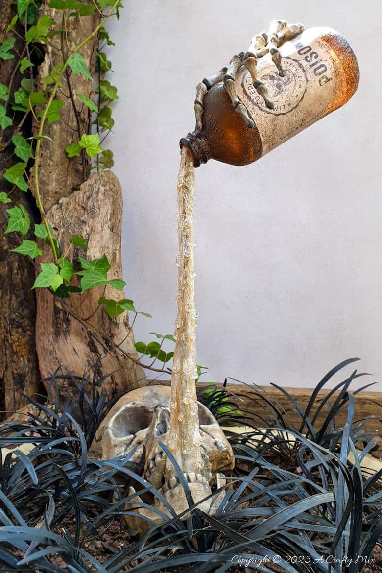 This Halloween, unleash your inner sorcerer with a DIY Skull and Floating Bottle Planter! We&rsquo;ll show you how to get the bottle to defy gravity and create a dripping poison effect that casts an otherworldly glow over the scene at night. The tutorial includes a free poison label printable and loads of pictures to guide you through the process. No special tools needed. #ACraftyMix