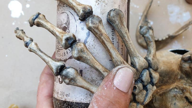 Use a 2 part epoxy glue to attach the fingers to the bottle