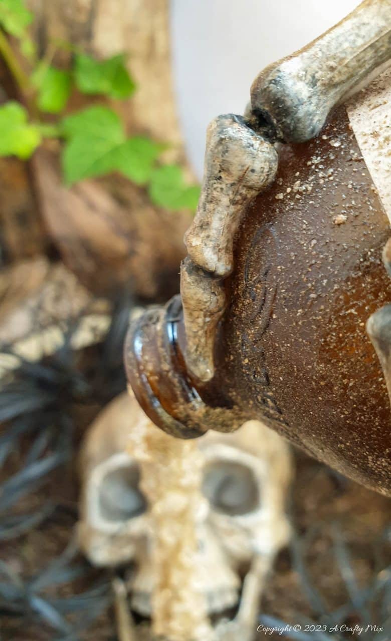 Unleash your inner sorcerer this Halloween with a DIY Skull and Floating Bottle Planter! We&rsquo;ll show you how to get the bottle to defy gravity and create a dripping poison effect that casts an otherworldly glow over the scene at night. The tutorial includes a free poison label printable and loads of pictures to guide you through the process. No special tools needed. #ACraftyMix