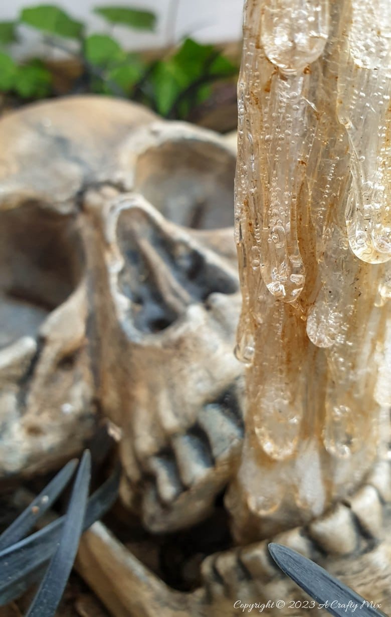 Unleash your inner sorcerer with this DIY Skull and Floating Bottle Planter tutorial! We&rsquo;ll show you how to get the bottle to defy gravity and create a dripping poison effect that casts an otherworldly glow over the scene at night. The tutorial includes a free poison label printable and loads of pictures to guide you through the process. No special tools needed. #ACraftyMix