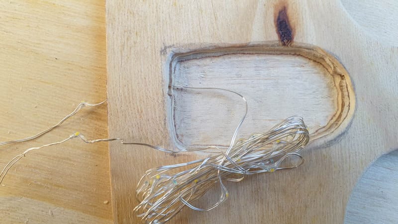 Thread the lights through the small hole in the wooden handle