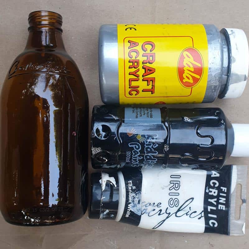 To give a glass bottle a metallic make over you'll need cheap craft paint and mod podge