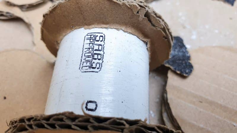 Slide the cardboard ring over the PVC pipe
