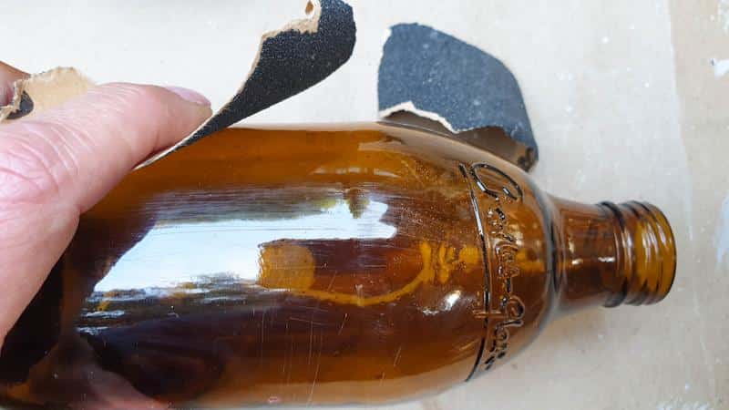 Sand the bottle to give the Mod Podge something to grip onto