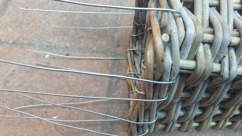 Thread the baling wire into the neck of the basket and bend to secure