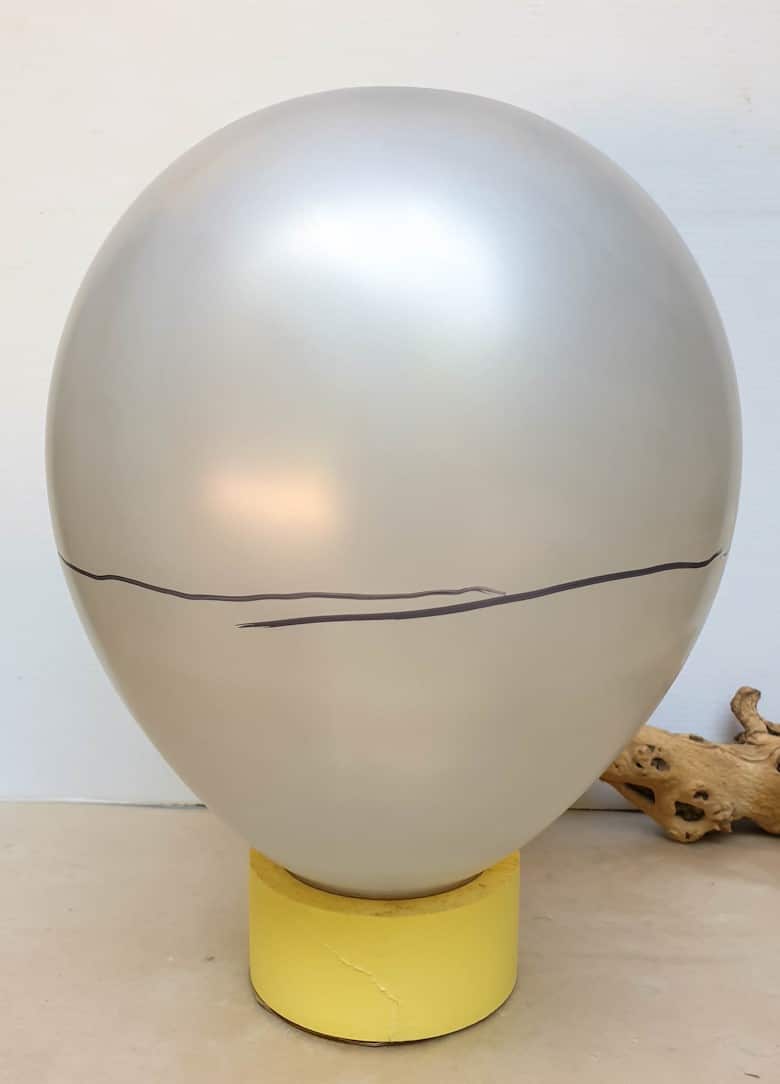 Use a permanent marker to draw a line all the way around the balloon