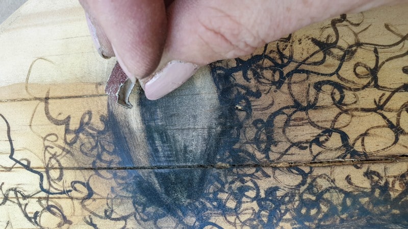 Use sandpaper to "erase" the scorch pen marks or smudge them
