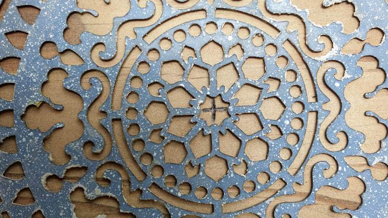 Find the center point on the piece of wood and mark it off. Place the middle of the stencil on the mark
