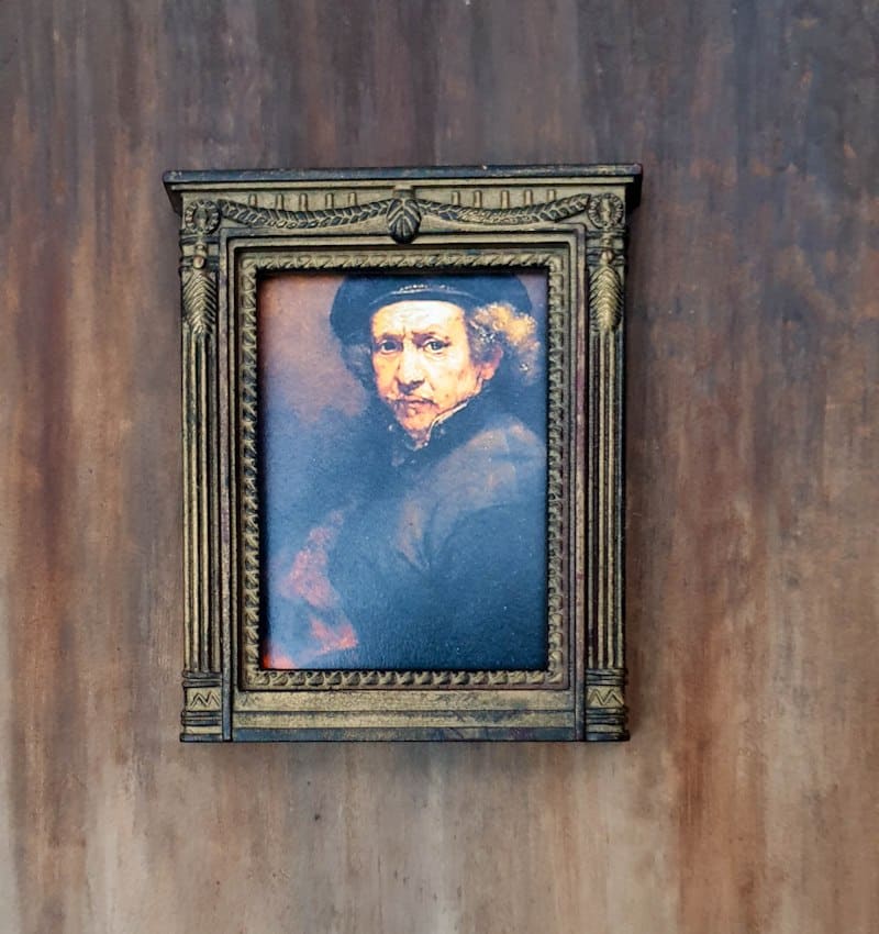 Glue the small portraits to the cardboard wall