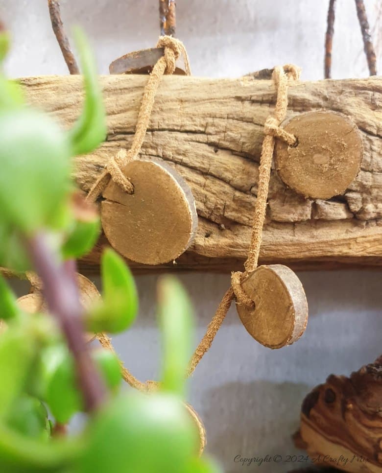Small slices of wood strung together with leather cord. The slices have been stained with "rust dust"