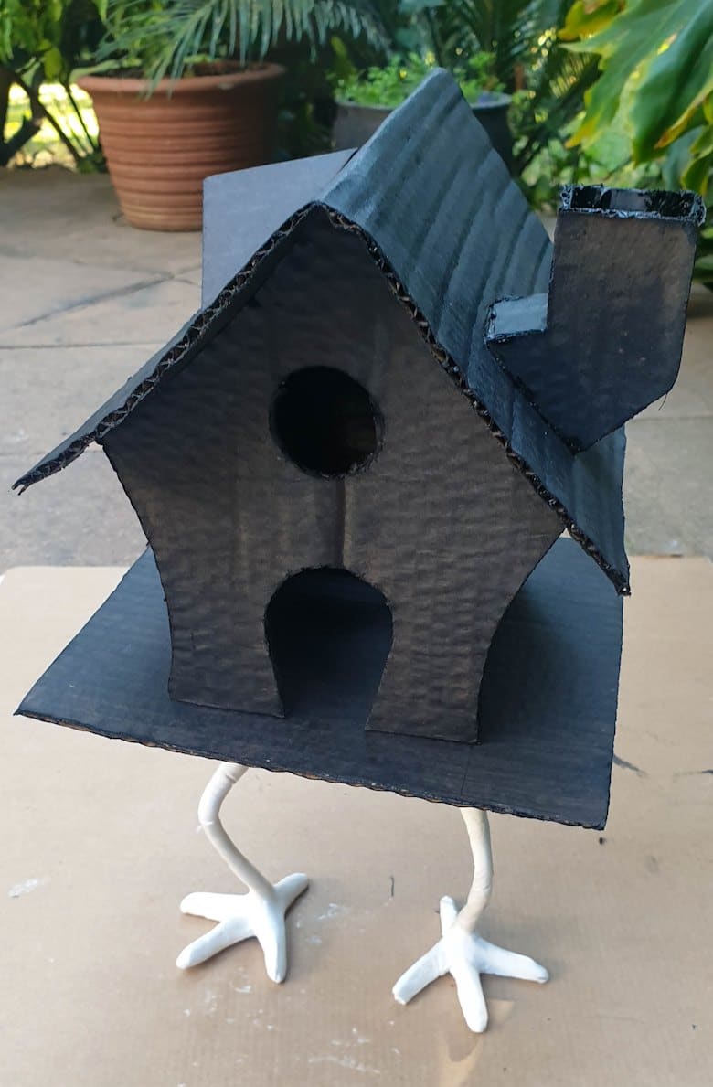 Baba Yaga's house painted black and resting on wiry clay chicken legs