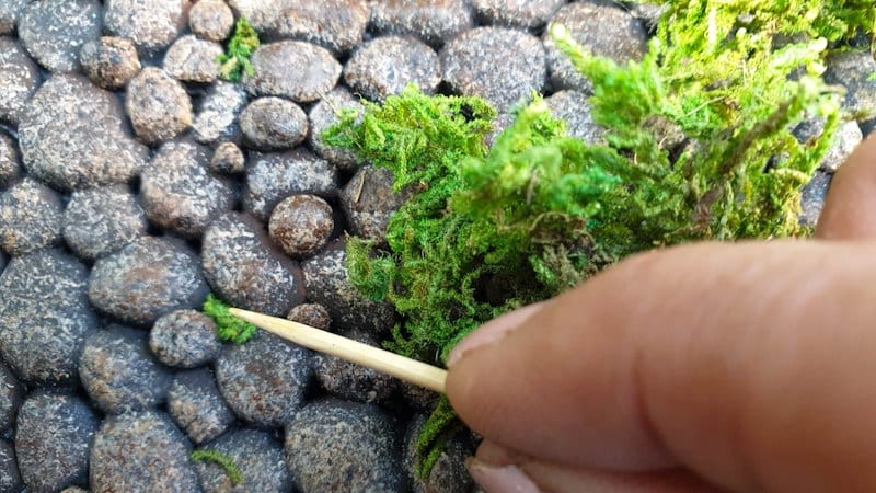 Fill any obvious holes between the stone cladding with moss