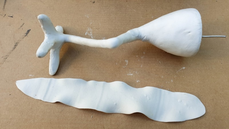 Use a long flat strip of clay to wrap around the legs