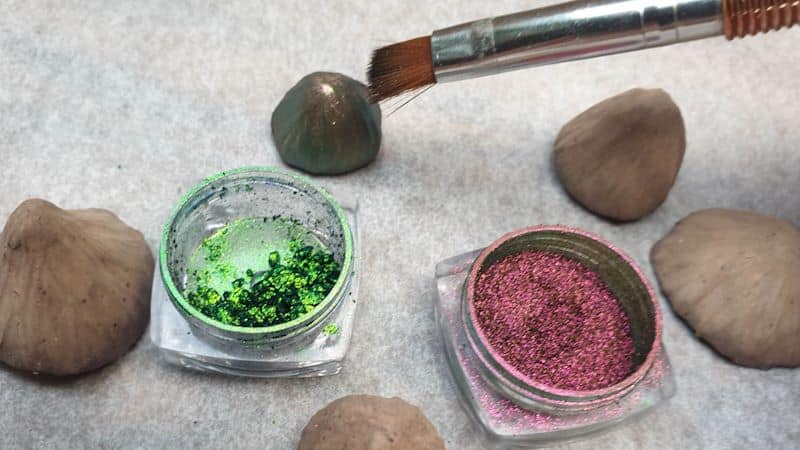 Use aa soft bristle brush to apply the shimmering eyeshadow to the clay