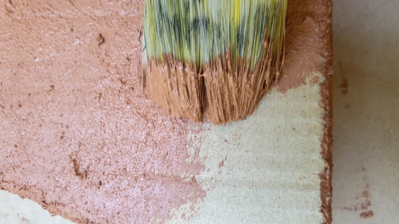 Use an old paint brush to apply the terracotta paint mixture