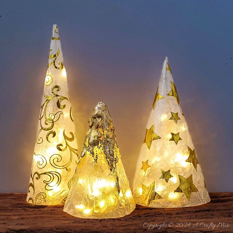 Get ready to add a little sophistication to your decor with these elegant and easy to make tabletop trees that will brighten up any room in your home. Made from paper napkins and filled with fairy lights, these Christmas decorations are perfect for small spaces and look beautiful on a table, mantle or bookshelf. Go glam with hints of gold or use napkins that match your table d&eacute;cor.