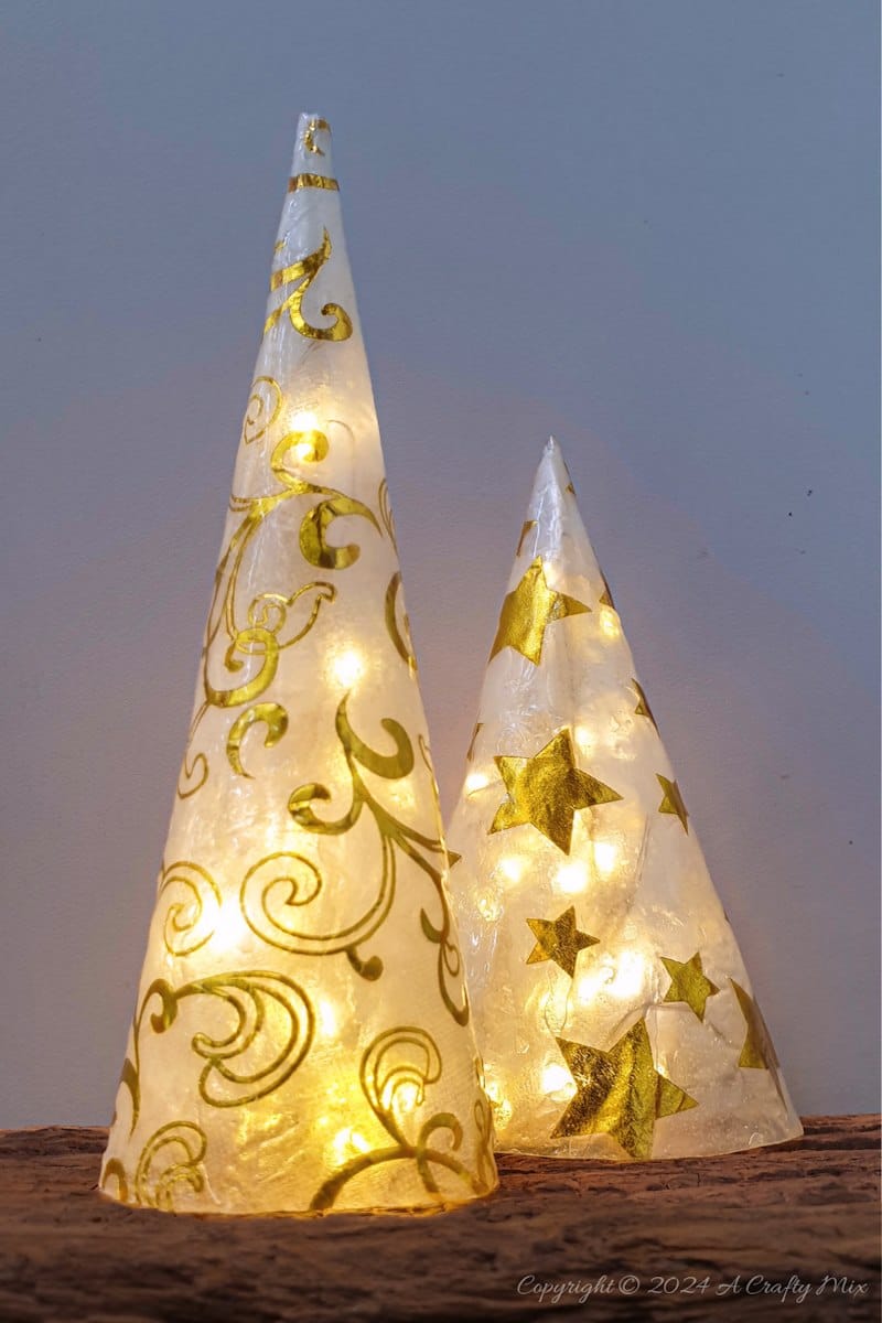 Get ready to add a little sophistication to your decor with these elegant and easy to make tabletop trees that will brighten up any room in your home. Made from paper napkins and filled with fairy lights, these Christmas decorations are perfect for small spaces and look beautiful on a table, mantle or bookshelf. Go glam with hints of gold or use napkins that match your table d&eacute;cor.