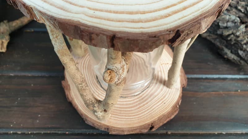 A basic fairy lantern frame consisting of a glass jar, wood slices and twigs