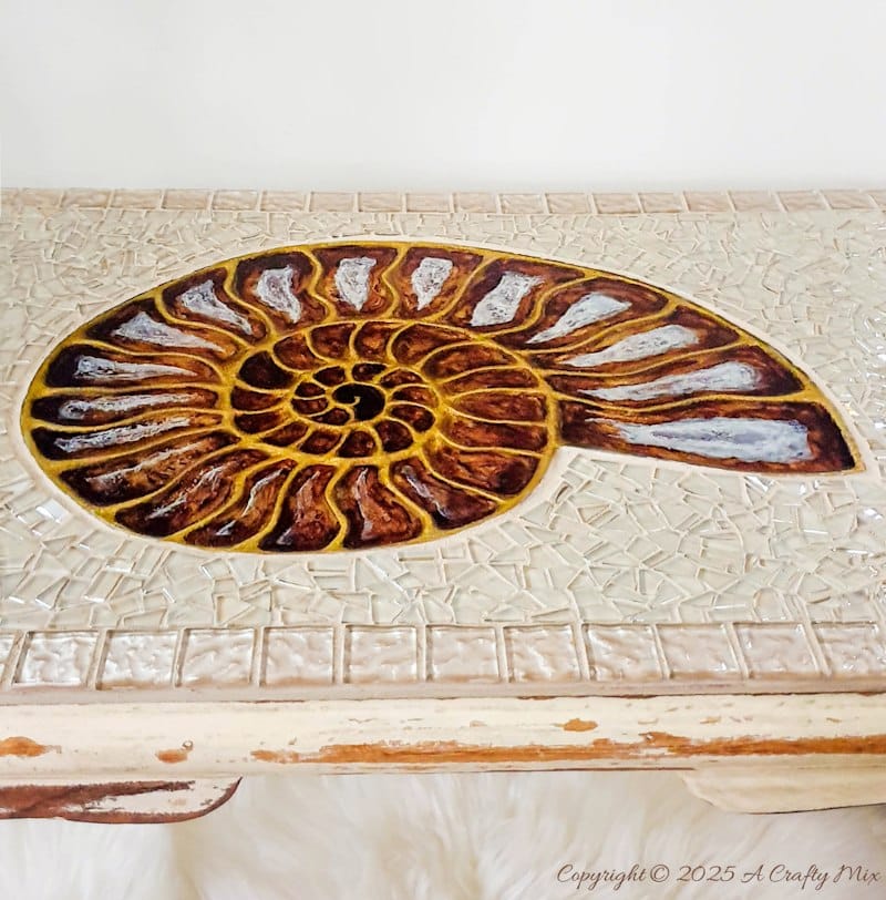 Looking for a unique way to breathe new life into an old piece of furniture? We&rsquo;ll show you how we gave a water-damaged tabletop a gorgeous &ldquo;mosaic and ammonite inlay&rdquo; makeover. This comprehensive guide provides detailed, easy-to-follow steps (with loads of photos) that will help you create your own masterpiece from start to finish. And you don&rsquo;t need any fancy materials to pull this one off either.