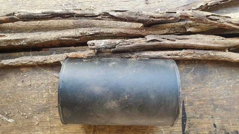 Paint the tin can black or a dark colour that tones in with the twigs