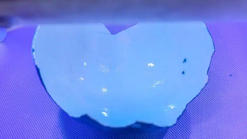 Cure the gel nail polish or 2-minute resin under a UV light.