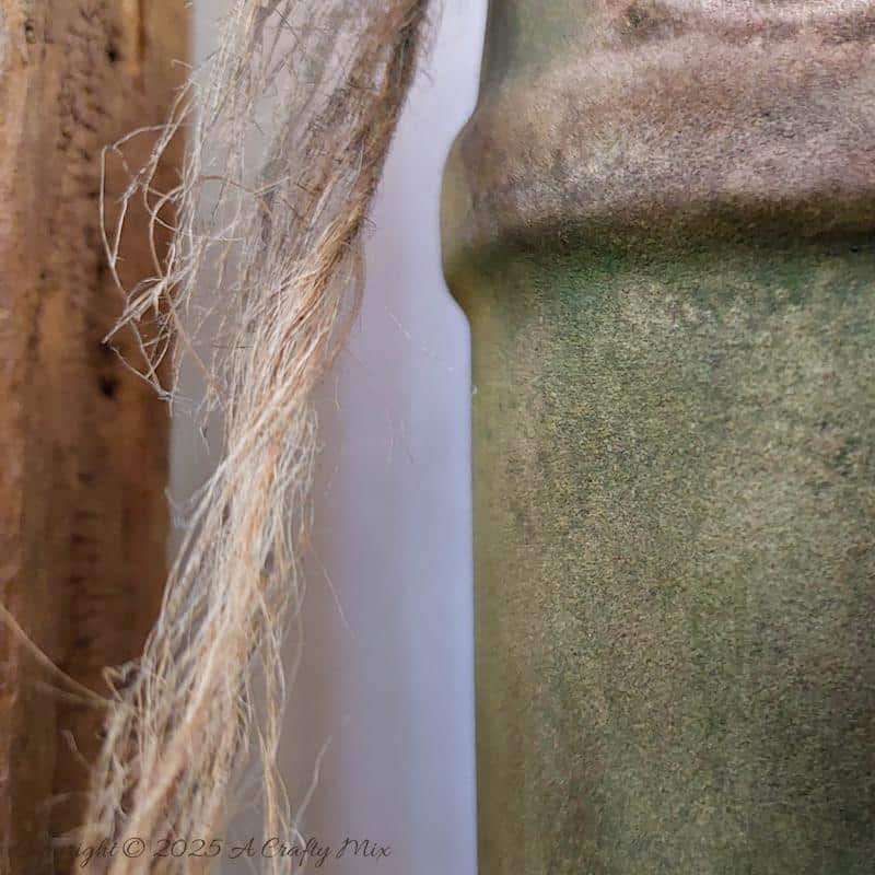 Upcycle ordinary bottles into old world treasures with this easy DIY. This beginner-friendly tutorial teaches you how to create an authentic antique clay finish using simple powdered food coloring and texture paste. Perfect for rustic or old-world d&eacute;cor.