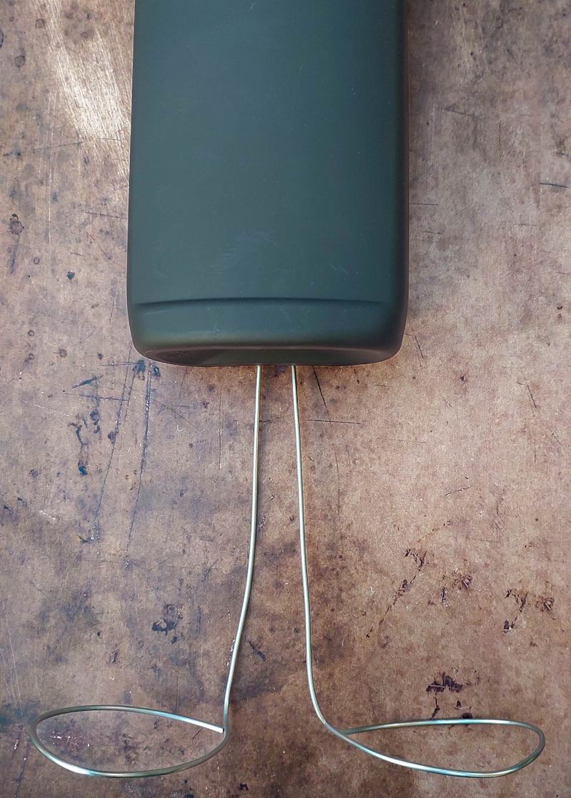 A view of the upcycled bottle and wiry legs before they've been joined together