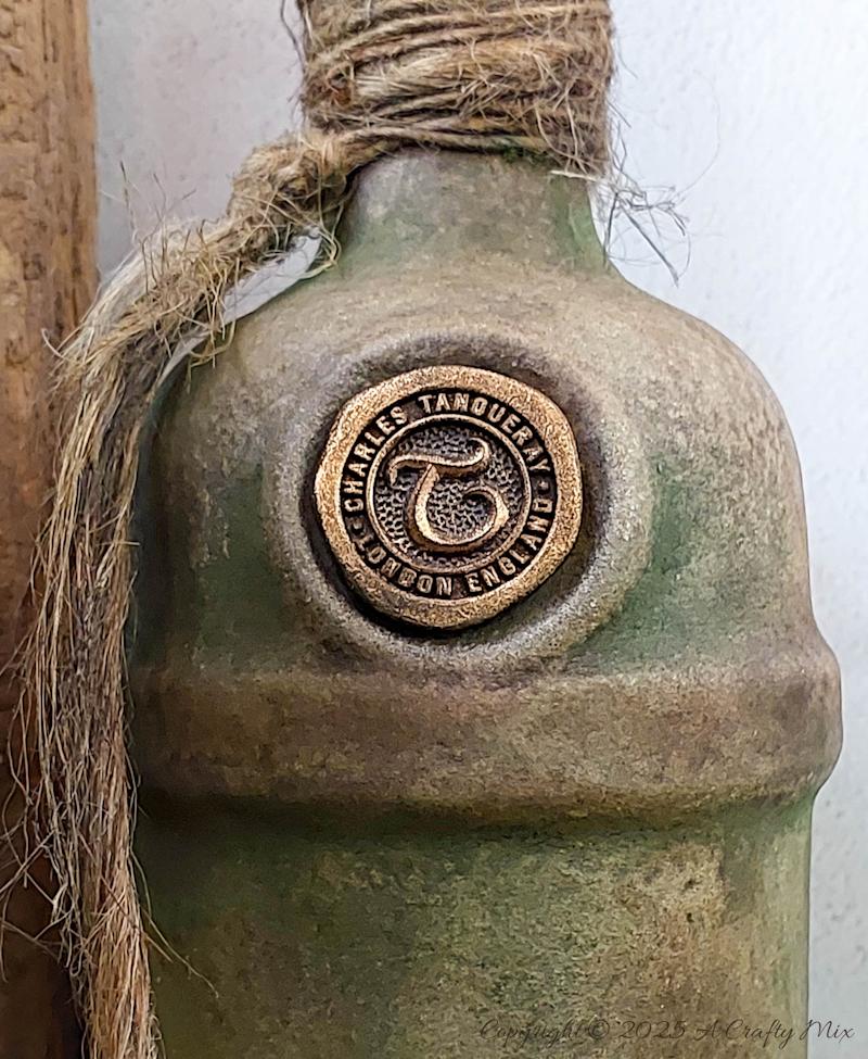 Upcycle ordinary bottles into old world treasures with this easy DIY. This beginner-friendly tutorial teaches you how to create an authentic antique clay finish using simple powdered food coloring and texture paste. Perfect for rustic or old-world d&eacute;cor.