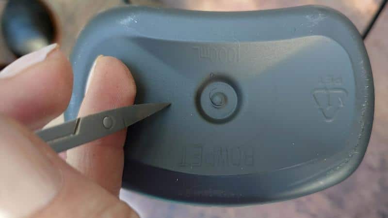 Use a sharp object to poke two holes in the bottom of the plastic bottle