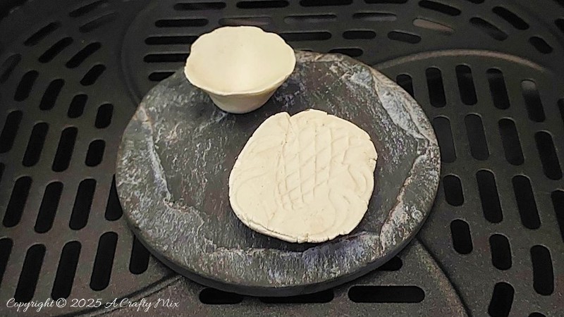 Place the clay on a heat-safe tray or ceramic plate